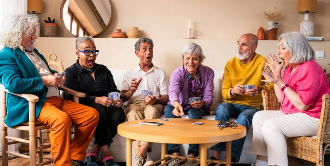 Elderly Residents Play Card Games in Community Lounge of Independent Living Facility