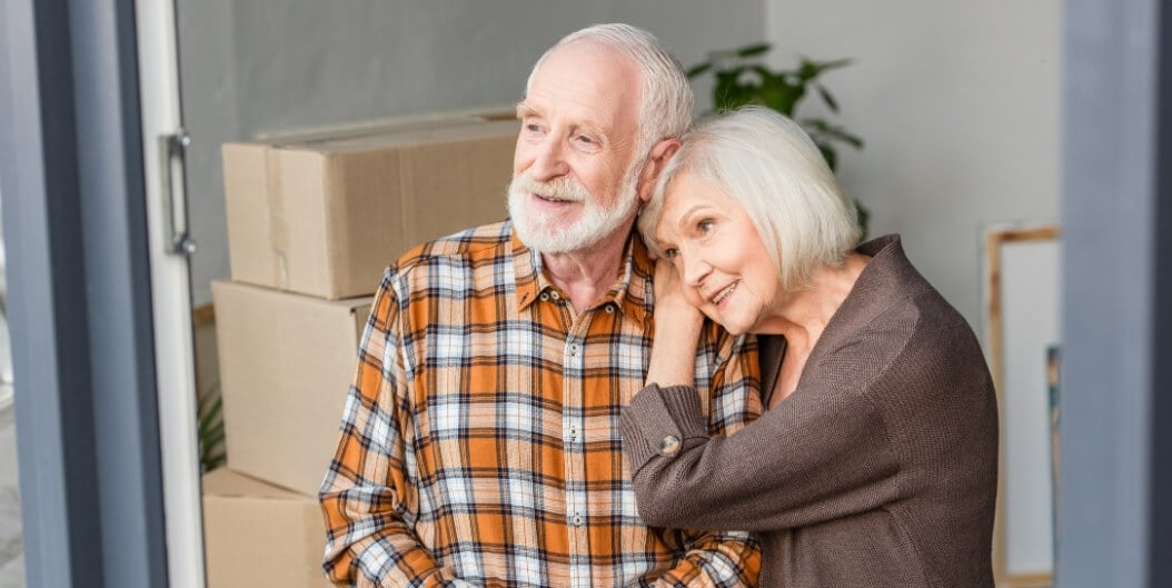 Elderly Couple Embracing amid Moving Boxes at Independent Living Facility