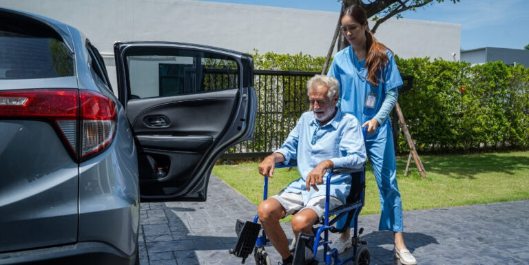 Female Nurse Assisting Resident into Car at Independent Living Facility